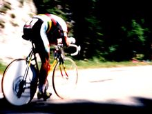 Greg Lemond at the 1990 Tour de France Villard-de-Lans time trial. Greg is on a road bike with aerobars and a rear Campagnolo disk wheel. He is wearing the rainbow jersey of the World Champion.