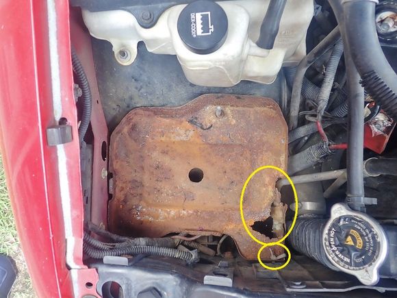 Before. That one corner is so rusted out that it's about to collapse in that direction under the weight of the heavy battery. My previous quick-fix was to replace a missing bolt with a plastic zip tie.