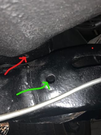 This picture shows the side of the frame.  Does the parking brake cable route where the green arrow is pointed, into the frame and then out the hole shown in the prior picture with the blue arrow.  Finally thru the firewall into the car where the red arrow is pointed. 
