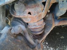 You can see that the bushing is attached to the flange(above) that comes off the frame. Below the bushing is the lower control arm. They bushing isn't in contact with the lower control arm now because the durango is jacked up.