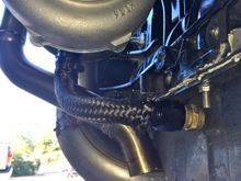 Dumps just under the oil pan.