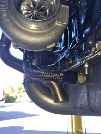 Dumps just under the oil pan.