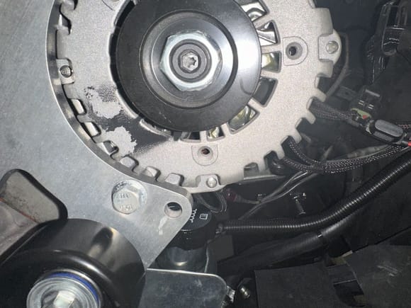 Belt dust on alternator case by pulley which is in the opening of the belt as it wraps around the pulley. See other pic