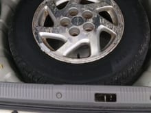 Full size tire in spare tire well - sticks out on top by about 1"