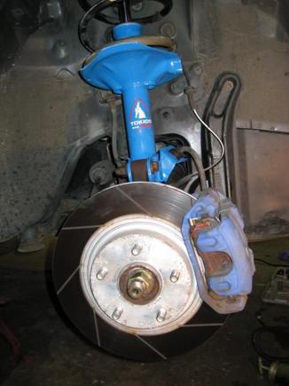 Freshly installed shocks   good view of my brakes.  Power Slot rotors with Hawk pads.  That blue on the caliper was the only high temp paint I had: the shocks being blue as well was just a coincidence.