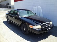 crown victoria police interceptor with new black paint job, oem radio installed, and back seats pulled from a taxi.