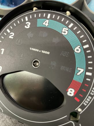 You can see the black circle in the center hole underneath the gauge face.    