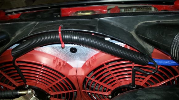 I made a small hole and zip tied the wiring in a larger loom to keep it out of the way...kind of rides underneath the curvature of the stock fan shroud so it's out of sight also...was cheap and fast..and so far it's been working great and no issues.  I soldered my fan leads together and ran one large 12 ga lead over to the stock radiator fan switch lead.