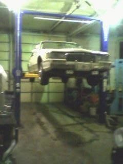 A cell phone pic I took one day while working on it. This was after I'd had the car for some time and had done a few mods to it. The car hoist is my dad's, he has a machine shop in town and the building came with it. Makes working on cars much easier. :-D