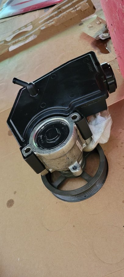 pump/reservoir assembly showing two metal clamps that secure reservoir to pump. They clamp around the area on the pump that the mounting bolts pass through