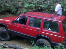 in a creek gettin ready to pull a tractor out