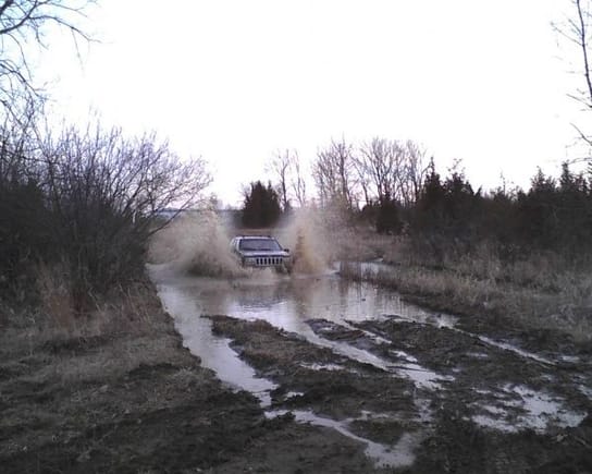 friends bone stock grand with bald tires going through 3 ft of mud and water