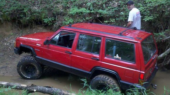 in a creek gettin ready to pull a tractor out