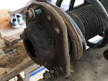 That bearing gets sandwiched between the upper spring plate and the strut mount 
