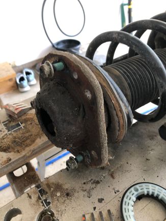 That bearing gets sandwiched between the upper spring plate and the strut mount 