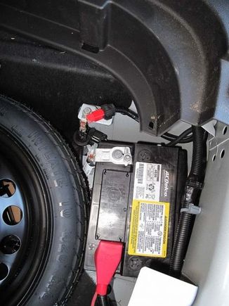 The battery cables in the back spare tire well . 