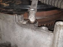 Gear selector cable holding nut - 10mm.  Move locking tab away from nut with small screwdriver.