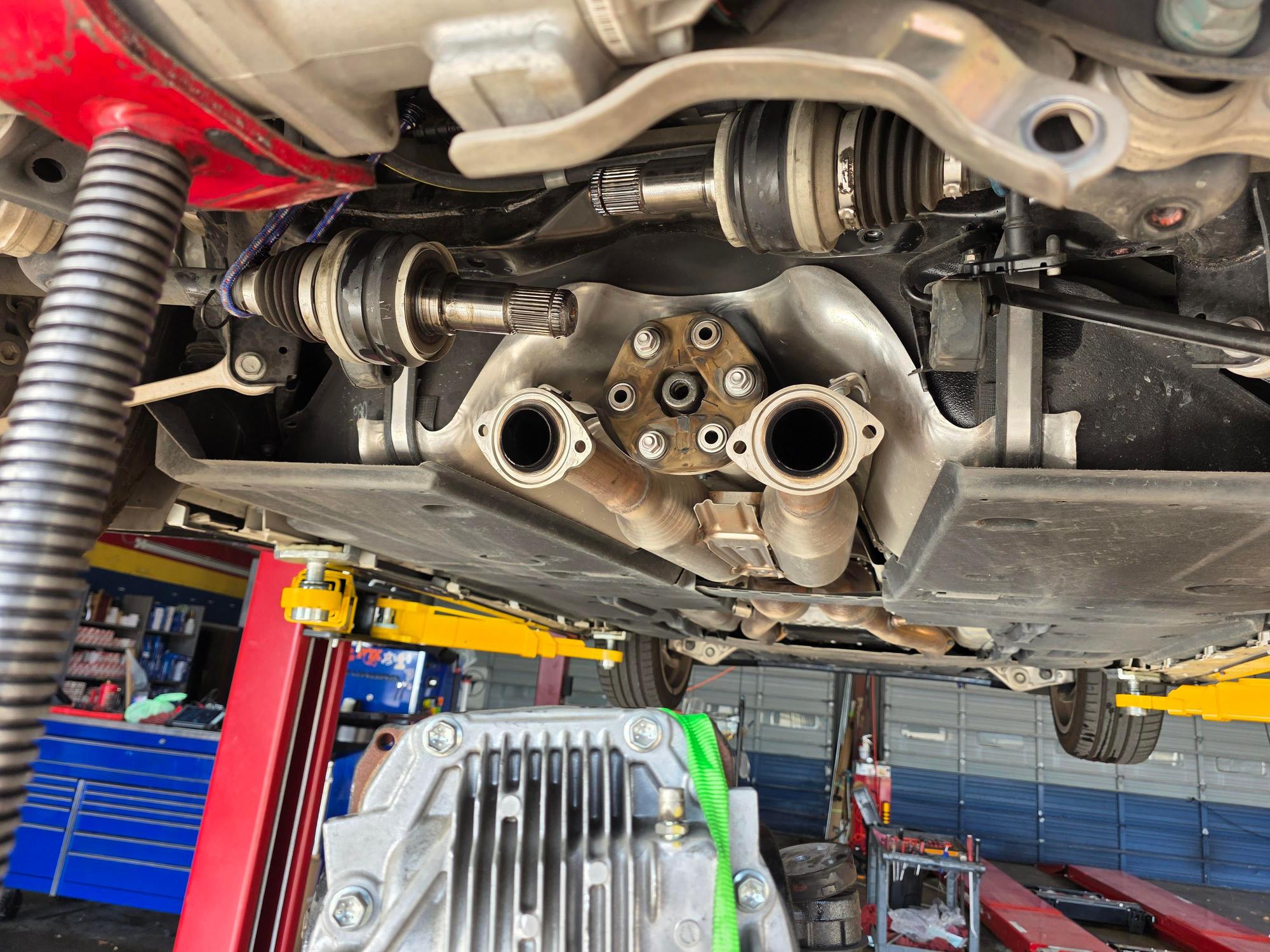 8. Here you can see the differential being dropped down. Also you can see the 3 nuts and bolts to the driveshaft that are removed. I also suspended the axles upward to avoid stress on the boots.