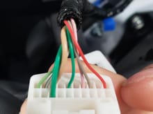 This is the same connector except turn so that you can see the other side.  Here you will see the thicker green wire notice it's the only wire on this side.  This is the 12-volt wire that will become live when you have your headlights on.
