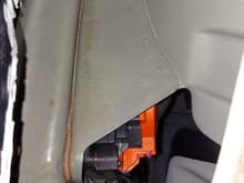 This is a view of the quarter panel where it mounts to the charge port structure.  If you look closely you can see the semi orange adhesive between the two.  The quarter panel is somewhat folded all along the adhesive. This is damage from the crash.  It amazes me how energy from the crash is spread out to areas like this.