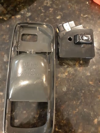 Backside of interior door handle plate with switch removed (North American passenger side)