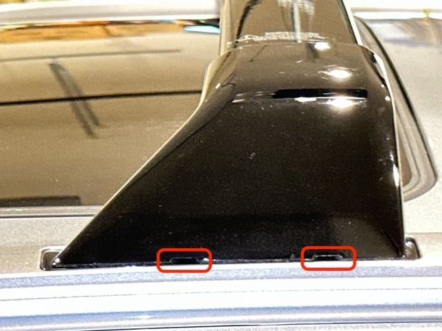 Slots at base of the plastic trim piece at one end of a cross bar