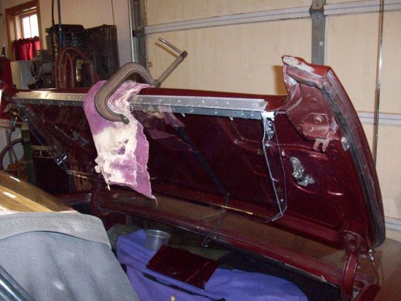 Put a 7/16”x7/8”x 43” long thin steel rectangular tube on the back side of the deck lid flange to spread the load by clamping the fiberglass between the assemblies.
Pop riveted a 1”x1”x1/16” x 43” long aluminum hinge to the 3/8” aluminum bar. The hinge sticks down approx. 1/8” below the 1” aluminum bar. The goal was to fold the wind screen under the deck lid when not in use. Forrest would have been smarter than to forget about the release handle, stupid is as stupid does. 
