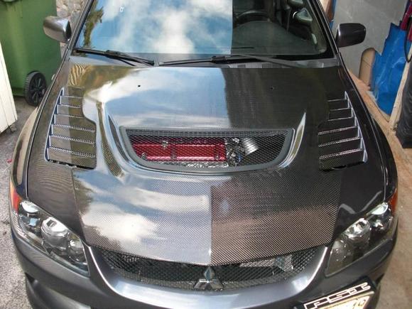 VIS Tracer Carbon hood. Got it used and badly damaged, yellow and dull. Sanded with 400 grit under the painted side for adhesion. Used 20 grit sandpaper to remove clear coat/resin all the way down to the fibers for the carbon side. Color matched then cleared with High build clear coat. No fish eyes or pin holes so im pleased on how it turned out. 
This was my first attempt at spraying a carbon hood!