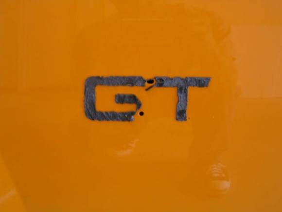 Note adhesive residue left behind after removal of fender badge.