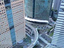 View looking down  between the buildings with the Yurikamome train to odaiba  just passing by. the shiodome station is very close to the ground lobby entrance