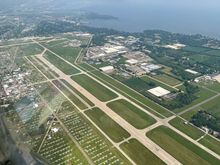 Runway 18/36 at Oshkosh, note the coloured dots on the runway that aircraft are directed to land on during the mass arrivals days. Also the lines of parked visiting aircraft.