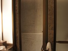 The shower door opens up, nearly hitting the bathroom sink, with only maybe a couple inches to spare.