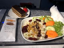 Choice of salmon or chicken salad. I was in 1B on an odd-numbered flight, so when the flight attendant reached us she only had one salmon left. I generously let my seatmate choose, and she took the salmon, so I got the chicken salad. I was expecting a lettuce salad with some chicken on top, but it was literally chicken salad topped with dried cranberries, with a couple of strands of (thankfully not romaine) lettuce. I would have been disappointed in the portion size had I not had another dinner 