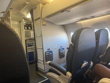 The lady in the bulkhead seat was served a completely full glass of white wine for the 45 minute ride