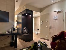 View from the Junior Suite couch. The bed is behind the wall with the TV. The toilet is further past the shower/bath, has a door. 