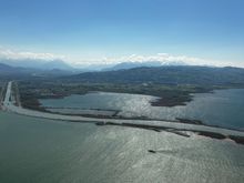 Man made entrance of the Rhein river on the Swiss side of the lake with mountains in the distance 