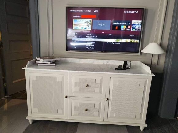 TV and dresser across the room from bed.  