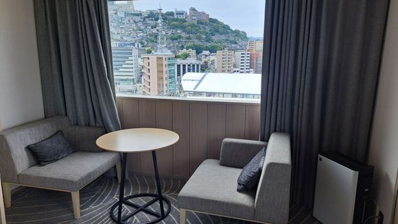 Table and two wide chairs by window facing the JR Station