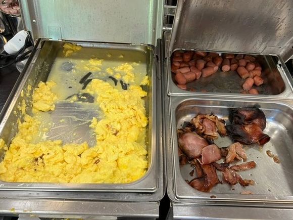 Burnt scrambled eggs and bacon at breakfast