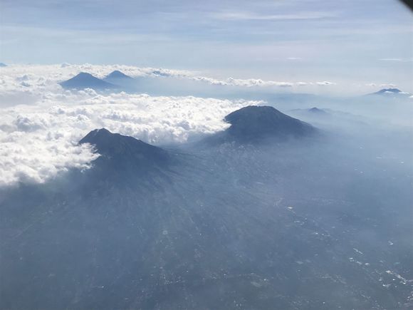 Mount Merapi Volcano and its sibling Mount Merbabu Volcano and other family.....

We departed from direction west to east and sitting on the left side of the aircraft you are treated to this amazing view!