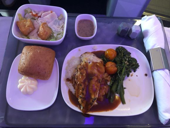 Clockwise from top: Caesar salad, rosemary chicken, whole grain bread with butter.  I let the steward know I have a shellfish allergy and he did not plate the harissa shrimp, he also prepared my tray first.
