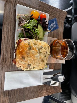 AS 682 DEN-SEA 11:50 AM departure. Described as a Brisket Torta. It was a warmed brisket and chees (not sure what cheese) and side salad. Warm nuts and drinks served earlier. It was a sandwich which was tasty but coulds have used some BBQ or other sauce to moisten it up a bit.