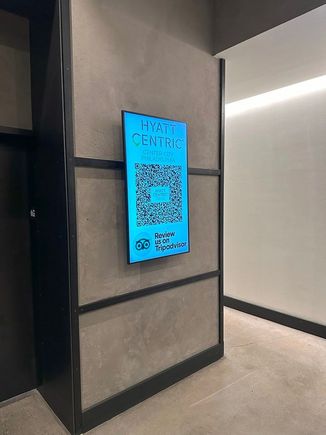 Giant screen in the first-floor entry lobby soliciting TripAdvisor reports