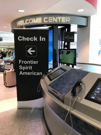 Poorly-placed sign in the center of baggage claim that's supposed to direct passengers to the escalator between carousels 2 & 3 for check-in. There is an identical banner near the said escalator. 