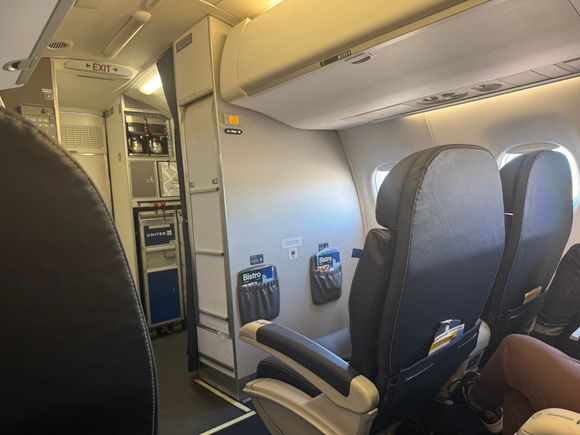 The lady in the bulkhead seat was served a completely full glass of white wine for the 45 minute ride