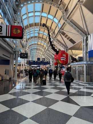 Gate signs at ORD with the Chicago Blackhawks logo to celebrate the hockey teams 100th anniversary. The replica of Sue the dinosaur also has a Blackhawks jersey. Goes along with United's 100th anniversary.