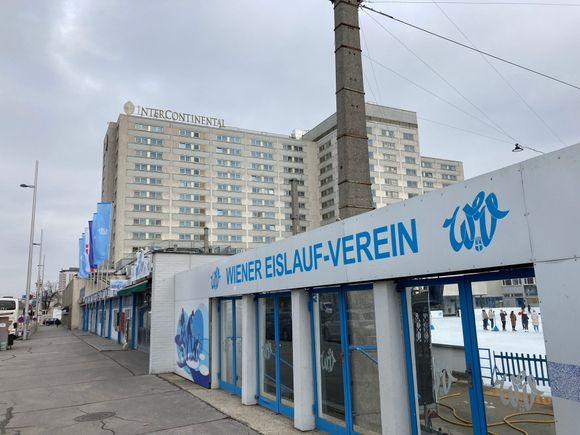 The hotel building is shaped like a T and sits next to the iceskating rink