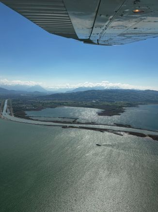 Man made entrance of the Rhein river on the Swiss side of the lake with mountains in the distance 