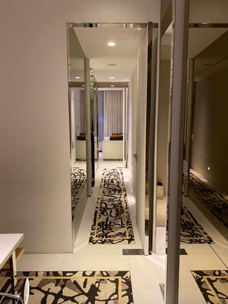 Interior hallway to bedroom, lined with wet bar room and main bathroom.