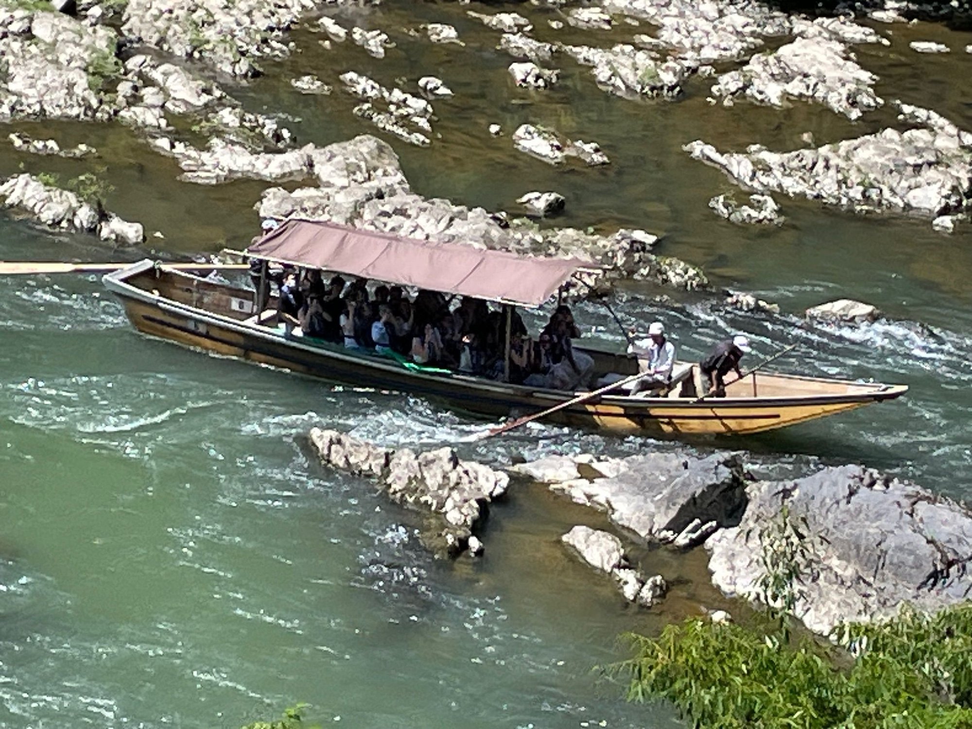One of the river boats. There is a guy in the back and two guys upfront.